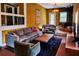 Comfortable living room features gray sofa and chairs, a wood-burning stove, exposed brick floor and unique decor at 10975 Hutcheson Ferry Rd, Chattahoochee Hills, GA 30268