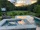 Picturesque pool and spa area with lounge chairs and tranquil views of a lush green landscape at 10975 Hutcheson Ferry Rd, Chattahoochee Hills, GA 30268