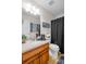 Well-lit bathroom with a wooden vanity, granite countertops, and a shower-tub combo at 101 Constance Dr, Locust Grove, GA 30248