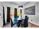 Bright dining room features a glass table, chandelier, modern art, and floor-to-ceiling black curtains at 101 Constance Dr, Locust Grove, GA 30248