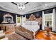 Opulent main bedroom boasting an ornate gold bed frame, hardwood floors, and a modern ceiling fan at 101 Constance Dr, Locust Grove, GA 30248