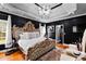 Luxurious main bedroom with a tray ceiling, dark walls, decorative lighting, and a statement headboard at 101 Constance Dr, Locust Grove, GA 30248