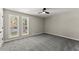 Well-lit bedroom featuring gray carpeting and two large windows at 1483 Hidden Hills Pkwy, Stone Mountain, GA 30088