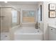 Relaxing bathroom with soaking tub, walk-in shower, and window at 7175 Linden Dr, South Fulton, GA 30349