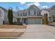 Two-story house with green siding, stone accents, and a three-car garage at 555 Winder Trl, Canton, GA 30114