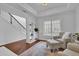 Bright living room with hardwood floors, built-in shelving, and a view of the staircase at 555 Winder Trl, Canton, GA 30114