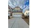 Two-story exterior elevation with a white brick facade and a spacious two-car garage with a concrete driveway at 3990 Cavalier Way, Duluth, GA 30097