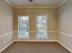 Bedroom with neutral walls, carpeting, and two large windows at 1019 Braelin Ct, Woodstock, GA 30189