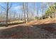 Sloped backyard with mature trees and wood fence at 3920 Stone Creek Cir, Cumming, GA 30041