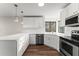 Modern kitchen with white cabinets, quartz countertops, and stainless steel appliances at 3920 Stone Creek Cir, Cumming, GA 30041