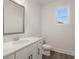 Modern bathroom with white vanity, toilet, and a window offering natural light at 7179 Linden Dr, South Fulton, GA 30349