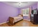 Charming bedroom with light purple walls, wood flooring, and a twin bed at 900 Sage Nw Ln, Conyers, GA 30012