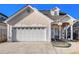 Charming home boasts a wide driveway, attached garage, and inviting front porch with decorative columns at 102 Prestwick S Way, Stockbridge, GA 30281