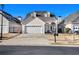 Charming home boasts a wide driveway, attached garage, and inviting front porch with decorative columns at 102 Prestwick S Way, Stockbridge, GA 30281