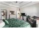 Bright main bedroom with decorative tray ceiling, sitting area, and view to the hall at 102 Prestwick S Way, Stockbridge, GA 30281