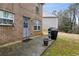 Back patio featuring a brick house, grill, and easy access to the backyard at 245 Fern Crest Dr, Lawrenceville, GA 30046