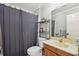 Clean bathroom with shower/tub combo, wood vanity, and metal shelving at 5352 Waterford Dr, Dunwoody, GA 30338