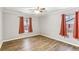 Bright bedroom with hardwood floors and two windows with orange curtains at 763 Windy Sw Dr, Stone Mountain, GA 30087