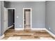 Bedroom featuring hardwood floors, a modern color scheme, and multiple doorways, providing a comfortable and stylish area at 9415 Grande Dr, Winston, GA 30187