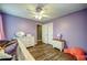 Lavender bedroom with laminate floors, ceiling fan, dresser, and closet at 1987 Allwood Ct, Lawrenceville, GA 30044