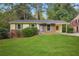 Brick ranch house with green accents, a covered carport, and a spacious lawn at 2907 Renfro Nw Dr, Atlanta, GA 30318