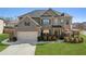 Brick two-story house with a three-car garage and landscaped lawn at 5110 Meridian Pass, Cumming, GA 30028