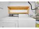 White laundry machines under a wooden shelf in the laundry room at 572 Edgewood Ne Ave # 309, Atlanta, GA 30312
