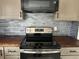 Stainless steel stove with gray glass tile backsplash at 3973 Woodland Se Cir, Conyers, GA 30013