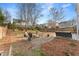 Large back yard with wooden fence, mature trees, stone firepit, and patio at 702 Berkeley Ter, Canton, GA 30115