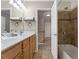 Bathroom featuring double vanity, open doorway, tile flooring, and tub shower combo at 702 Berkeley Ter, Canton, GA 30115