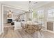 Bright dining area with wood floors, a view to the living room, and a stylish light fixture at 702 Berkeley Ter, Canton, GA 30115