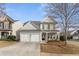 Traditional two-story home with stone accents, a well-manicured lawn, and an attached two-car garage at 702 Berkeley Ter, Canton, GA 30115