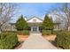 Inviting white farmhouse-style home with symmetrical landscaping and a covered porch, exuding curb appeal at 702 Berkeley Ter, Canton, GA 30115