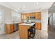 Bright kitchen with stainless steel appliances, island with seating, and light wood cabinets at 702 Berkeley Ter, Canton, GA 30115