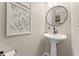 Cozy powder room with a pedestal sink, decorative mirror, and stylish wall art at 702 Berkeley Ter, Canton, GA 30115