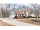 Brick home featuring a spacious driveway and attached garage at 305 Corrigan Trce, Peachtree City, GA 30269