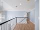 Second floor hallway with wood floors, white banister, and neutral walls at 305 Corrigan Trce, Peachtree City, GA 30269