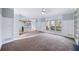 Open-concept living area with large windows and views of the kitchen and deck at 305 Corrigan Trce, Peachtree City, GA 30269