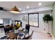 Modern dining area with glass table and four chairs, an accent wall, and a view to the outdoors at 684 Tarkington Rd, Stone Mountain, GA 30088