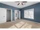 Blue bedroom with tan carpet, ceiling fan and double closets at 390 Wayside Dr, Lawrenceville, GA 30046