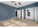 Blue bedroom with tan carpet, ceiling fan, and double closets at 390 Wayside Dr, Lawrenceville, GA 30046