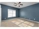 Blue bedroom with tan carpet, ceiling fan and double closets at 390 Wayside Dr, Lawrenceville, GA 30046