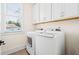 Convenient laundry room with white washer and dryer, and upper cabinets at 330 Mount Zion Rd, Hapeville, GA 30354