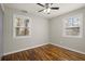 Bright bedroom with hardwood floors, ceiling fan, and two windows at 3460 Fairlane Dr, Atlanta, GA 30331