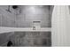 Updated shower with gray tile and built-in shelf at 3460 Fairlane Dr, Atlanta, GA 30331