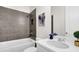 Modern bathroom with shower/tub combo, white vanity, and dark gray tile at 399 Tillman Pass, Woodstock, GA 30188