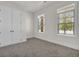 Bright bedroom with neutral walls, gray carpet, and double doors to closet at 399 Tillman Pass, Woodstock, GA 30188