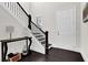 Elegant entryway with dark hardwood floors, a staircase with black railing, and a console table at 399 Tillman Pass, Woodstock, GA 30188