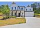 Two-story white farmhouse with gray stone accents, a large driveway, and landscaping at 399 Tillman Pass, Woodstock, GA 30188