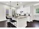 White kitchen with granite island, stainless steel appliances, and dark hardwood floors at 399 Tillman Pass, Woodstock, GA 30188